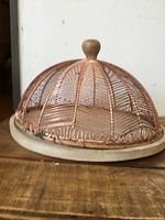 Front angled view of wood base with copper wire dome cover displayed closed on surface