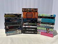 Three images displaying a variety of DVD TV series boxed sets and full seasons stacked in multiple piles on a white background with some titles clearly visible.