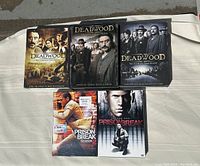 Five DVD box sets laid out showing Prison Break Seasons 1 and 2 and Deadwood Seasons 1, 2, 3 box art.