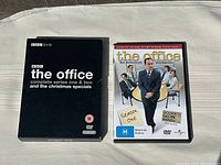 Two DVD sets on a white cloth background, showing the UK and US versions of The Office.