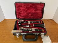 Yamaha clarinet disassembled in black case with red velvet lining, showing all main parts arranged neatly.
