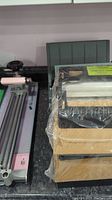 Stack of items including the 3M LS950 laminator and three Xyron 850 adhesive refills wrapped in plastic.