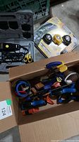 Lot overview showing Andis pet clippers in case, three LED headlamps in blister pack, and box of clamps including Irwin Quick Grip and spring clamps.
