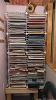 Full view of the two white wire racks filled with multiple pads and single sheets of various colored craft and card stock paper.