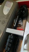 Full view of the tripod inside original box packaging, showing folded legs with flip locks and Manfrotto branding on side tube.