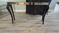 Front view of the mirrored sofa table showing curved legs and reflective tabletop.