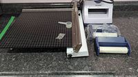 Overview of the electric paper trimmer, Xyron sticker maker, and refills on a countertop showing all items in the lot
