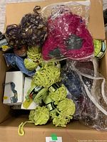 Top-down view of large box filled with various knitting yarn skeins and packs of embroidery floss.