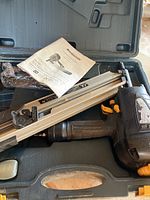 Mastercraft air framing nailer in black plastic case with manual visible on top.