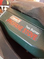 Close-up of Coleman logo and propane stove label on stove's carrying case.