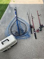 Overview of all items in the lot including two nets, three rods, reels, and a tackle box