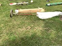 Two 9ft patio umbrellas with white canvas fabric, one still in box, laid on grass