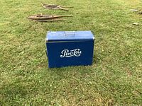 Full front and side view of the cooler placed on grass with snowshoes in background