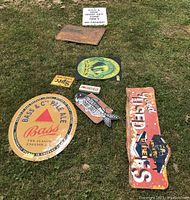 Wide group shot of eight metal and wood signs on grass