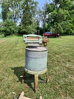 Front view of the vintage Beatty wringer washer showing the cylindrical tub, metallic finish, and attached wringer.