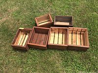 Photo of seven wooden crates on grass, showing different sizes and styles