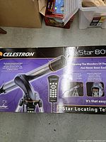Box front and top showing Celestron NexStar 80SLT telescope with hand controller and tripod, product branding and key features.
