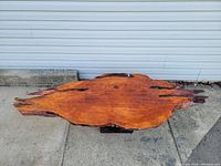 Top-down view of large irregularly shaped burlwood tabletop slab with lacquer finish showing natural wood grain and tones.