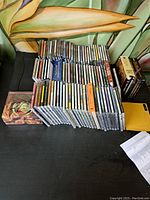Photo of the full lot of approximately 50 CDs laid out in rows showing condition and packaging.