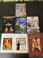 Photo showing seven DVDs in lot: The Pianist (Limited Soundtrack Edition), John Mayall 70th Birthday Concert, Peter Sellers movie, Elizabeth, The Queen, Indiana Jones.