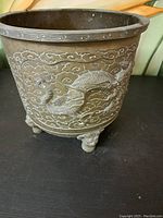 Full view of the solid brass flower pot showing dragon motif and feet