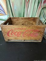 Front view of the wooden crate showing 'Drink Coca-Cola' logo in red print.