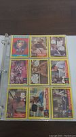 Nine 1987 Alf trading cards with yellow borders in a binder page, showing various scenes and characters.