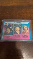 Photo of three 1978-79 O-Pee-Chee hockey top scorers cards featuring Mike Bossy, Marcel Dionne, and Guy Lafleur with pink background and player portraits, in plastic protective case.