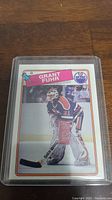 Photo of 1988-1989 Topps hockey card featuring Grant Fuhr in Edmonton Oilers uniform, encased in protective case.