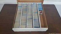 Top-down image of approx. 4500 O-Pee-Chee 89-90 hockey cards organized vertically in five compartments within a white cardboard storage box, with one visible card edge shown on the right side.