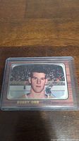 Front side of Bobby Orr rookie reprint hockey card with his image and name.