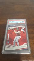 Photo of the 2021 Prestige Mac Jones rookie card graded PSA 9 in PSA slab showcasing card front and grade label.