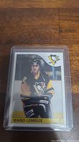 Front of the Mario Lemieux rookie reprint hockey card enclosed in plastic sleeve showing player in Penguins uniform.