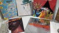 Five classic rock vinyl albums displayed, showing front covers including Utopia, Bob Dylan, unknown colorful abstract, Joe's Garage, and Double Platinum compilation album.