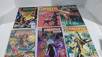 Photo shows six Marvel comics spread out displaying front covers.