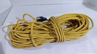 Photo of a long yellow extension cord coiled with visible male plug and female socket.