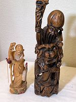 Pair of carved wood Shou Lao longevity figures, tallest 17 inches, shown together for size and detail comparison