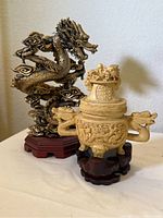 Front view of both dragon figurine and vessel on bases.