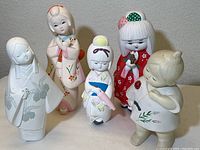 Full view of five Hakata dolls arranged together, showing varying colors and sizes