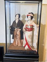 Dolls in display case showing full-length view of both the man and woman dolls in traditional Japanese wedding attire.