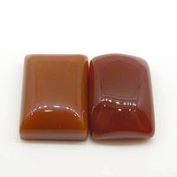 Two rectangular cabochon orange carnelian gemstones displayed side by side on a white background, showing their shape and color.