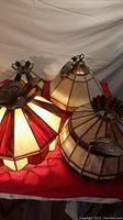 Five Tiffany-style stained glass lampshades with red, white and cream colors, various geometric stained glass patterns. Some lamps shown mounted on metal hardware tops.