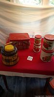Full view of the picnic canister set including jug, metal box, and five fruit-decorated canisters
