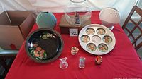 Full view of the lot on a red tablecloth including the Florida tray, vases, plates, and figurines