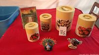 Lot contents showing all four ceramic canisters with floral designs and two bird figurines, on red tablecloth