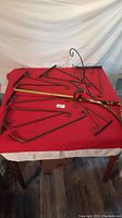 Full view of all steel brackets and decorative bird bracket arranged on a red surface to show quantity and condition.
