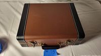 Closed vintage-style portable turntable case brown with black edges and black handle