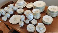 Full view of the large set laid out including plates, cups, saucers, bowls, and serving dishes.