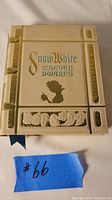 Front view of the Snow White storybook styled makeup palette with embossed text and silhouette.