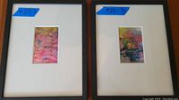 Two framed watercolour paintings with visible price tags and visible artist signature, one frame has a scratch.